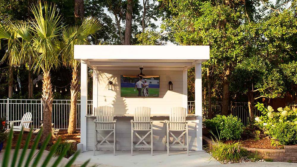 White pergola with insulated roof including an integrated TV - Model R-Shade pergola by Azenco